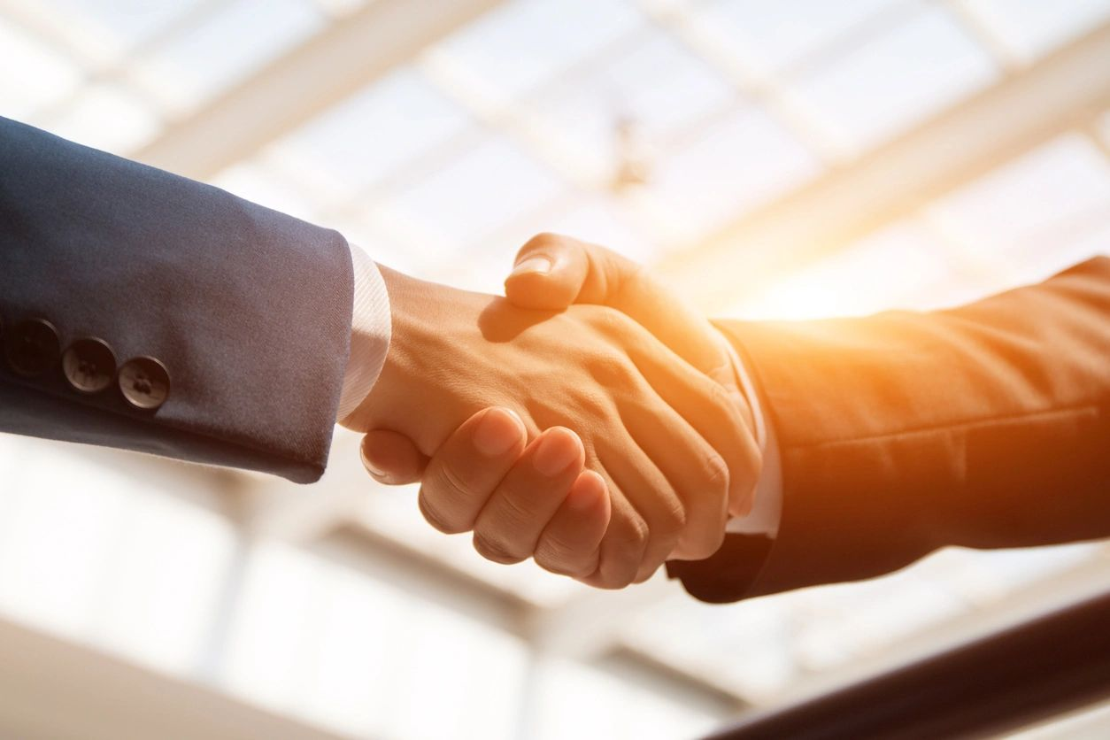 Two people shaking hands in a room.